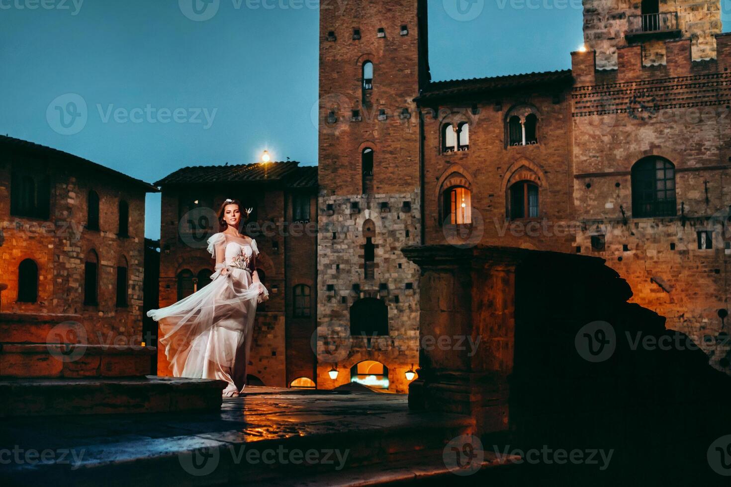 ein Braut im ein Weiß Kleid im das alt Stadt, Dorf von san gimignano.a Mädchen Spaziergänge um das Stadt im italien.toskana. foto