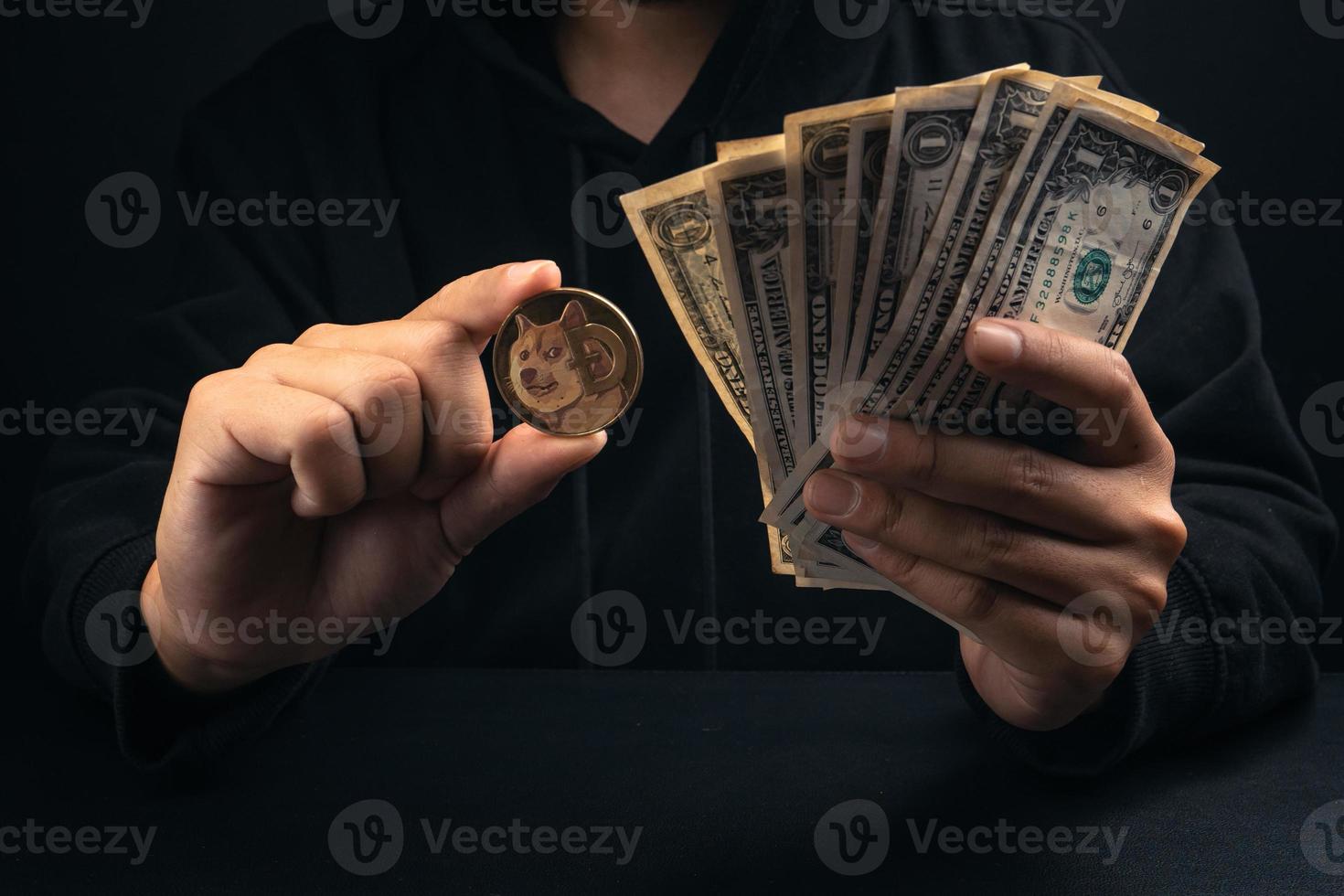 Geld und goldene Dogenmünzen in der Hand des schwarzen Haubenmannes foto