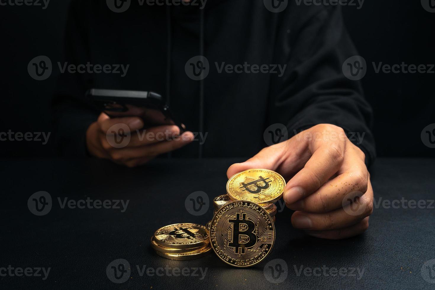 ein goldener Bitcoin in der Hand eines mysteriösen Mannes. foto