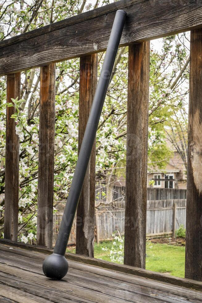 Stahl Keule oder Abonnieren auf ein hölzern Deck, Fitness Konzept mit unkonventionell Ausrüstung, Frühling Landschaft foto