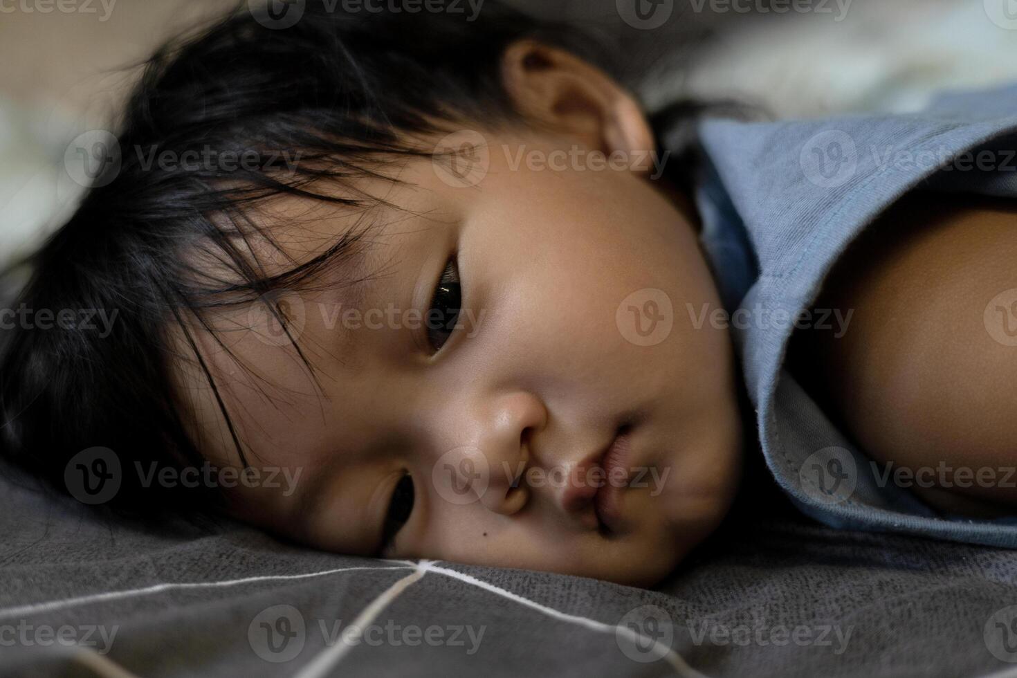 wenig Junge lügen Nieder auf das Bett foto