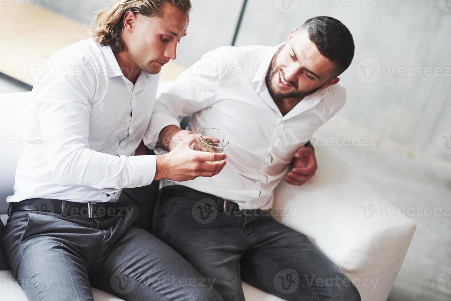hohe Hoffnungen. zwei Teamkollegen unterhalten sich in der Pause und trinken Whisky foto