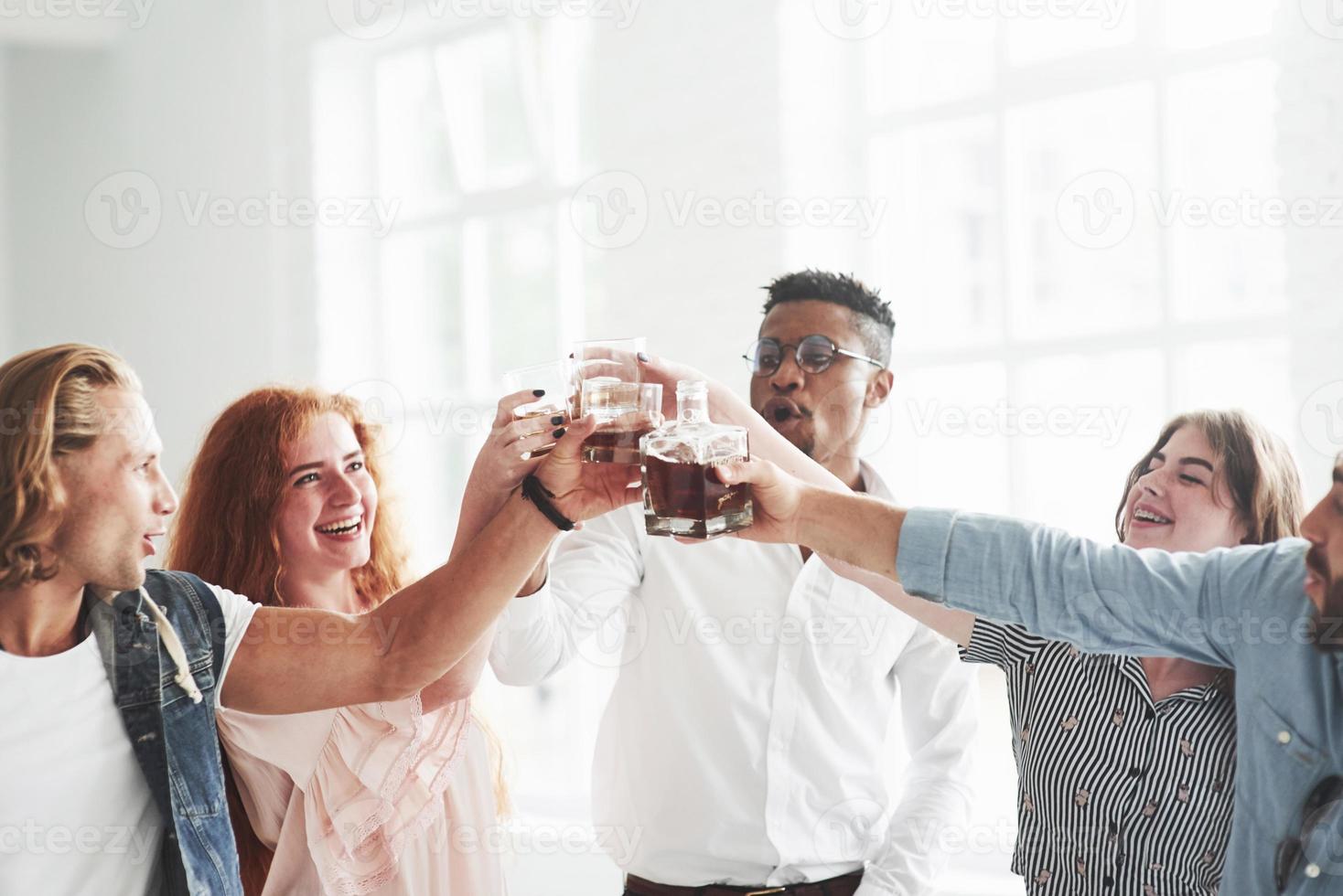 für die Zukunft. Teamkollegen trinken Whisky und lachen wegen des erfolgreichen Deals foto