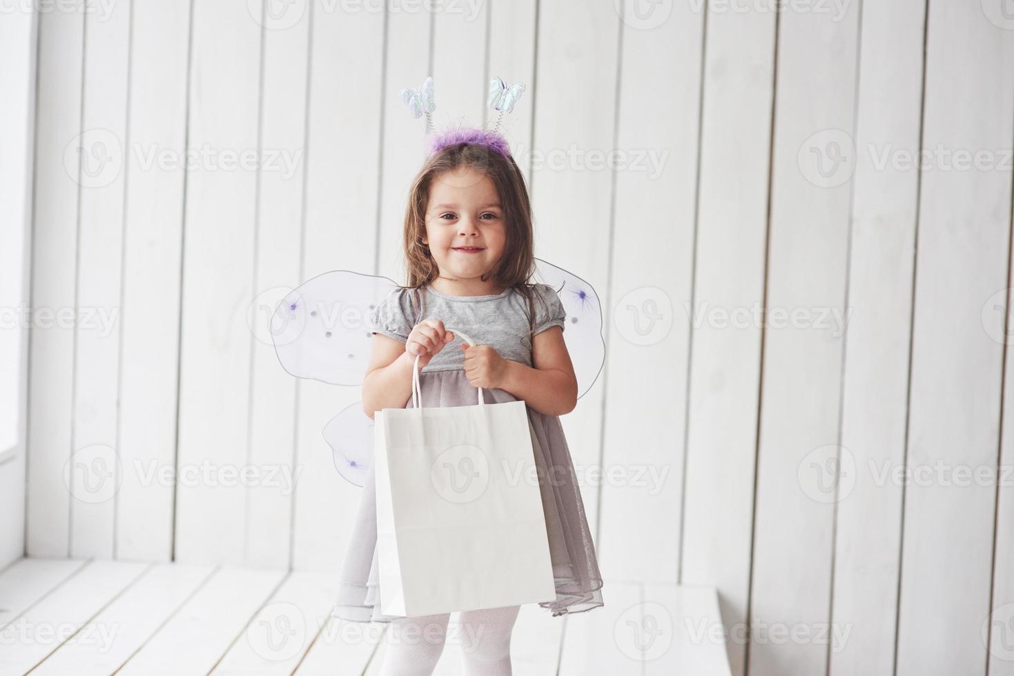 Geschenkbox. schönes kleines Mädchen mit Feenkostüm, das Spaß beim Posieren für die Bilder hat foto