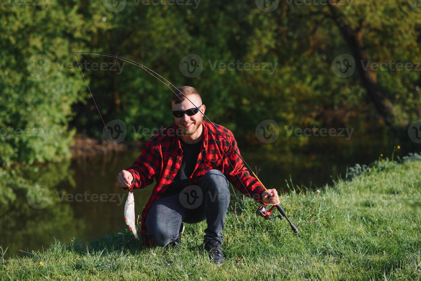 Mann entspannend und Angeln durch Seeufer. Wochenenden gemacht zum Angeln. Fischer männlich Hobby. Meister Köder. behalten Ruhe und Fisch An. Fischmann gehäkelt rotieren in das Fluss warten groß Fisch. Kerl fliegen Angeln foto