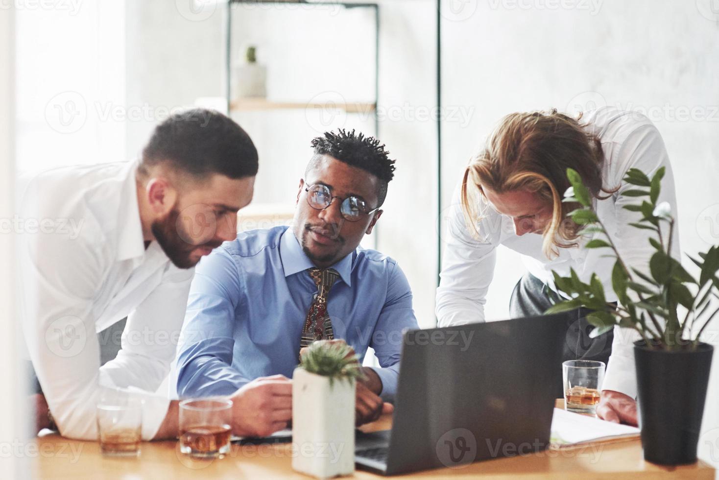 Büroangestellte unterhalten sich während ihrer Arbeit foto