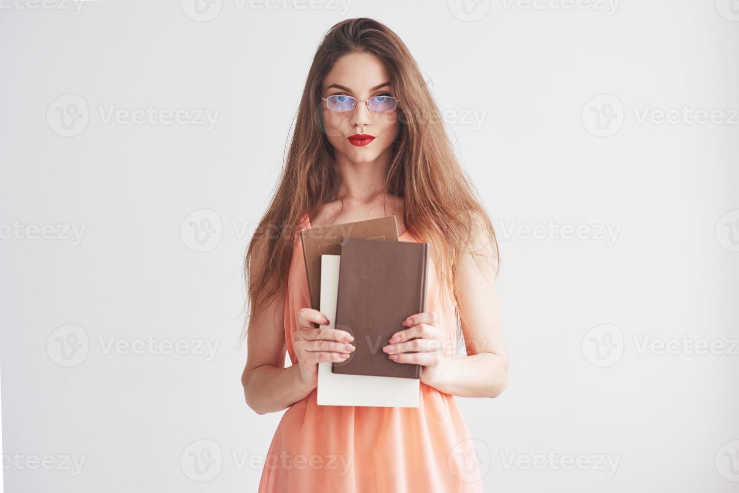 Foto einer jungen Frau mit Brille und roten Lippen, die die Bücher halten