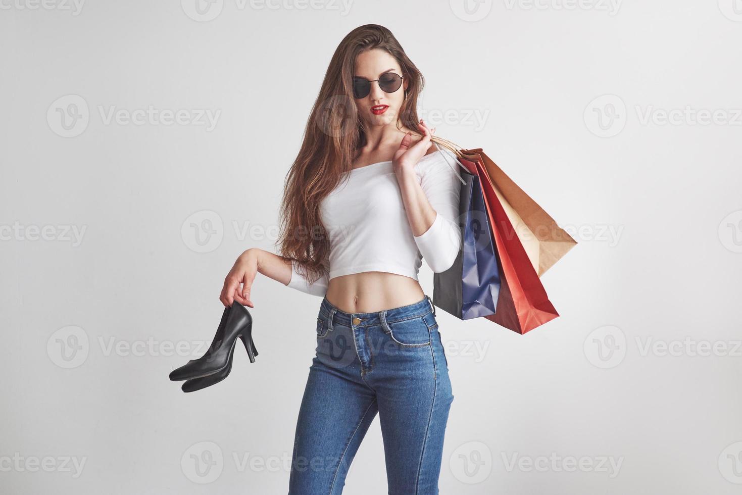 gerade vom Einkaufen. stilvolle junge Frau, die die Pakete mit Kleidung und Absätzen hält foto