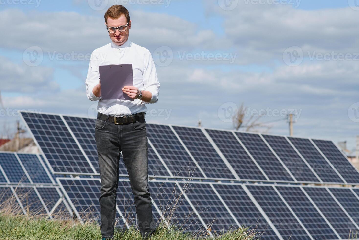 Solar- Paneele und Blau Himmelmann Stehen in der Nähe von Solar- Tafeln. Solar- Panel produziert Grün, ökologisch freundlich Energie von das Sonne. foto