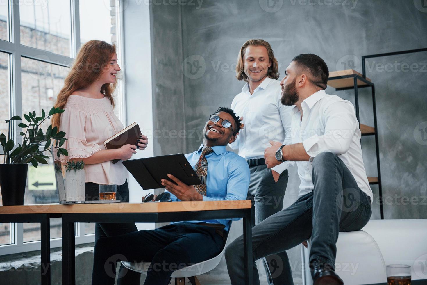 Wie sieht ein erfolgreicher Job aus. Gruppe gemischtrassiger Büroangestellter in formeller Kleidung, die über Aufgaben und Pläne sprechen foto