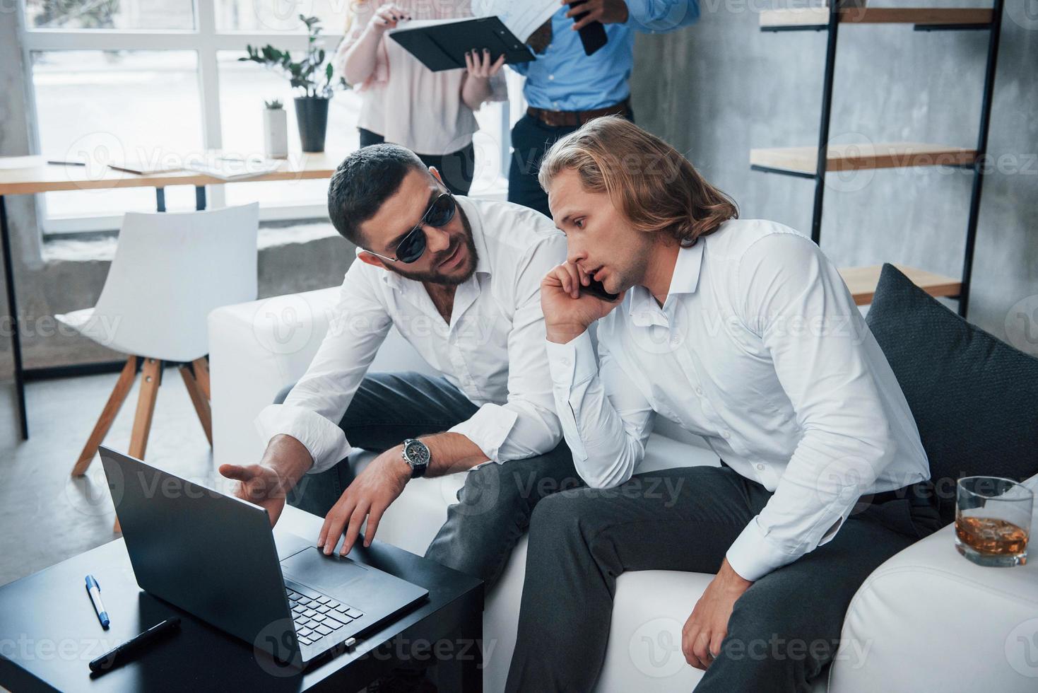 Umgang mit Partnern. Gruppe gemischtrassiger Büroangestellter in formeller Kleidung, die über Aufgaben und Pläne sprechen foto