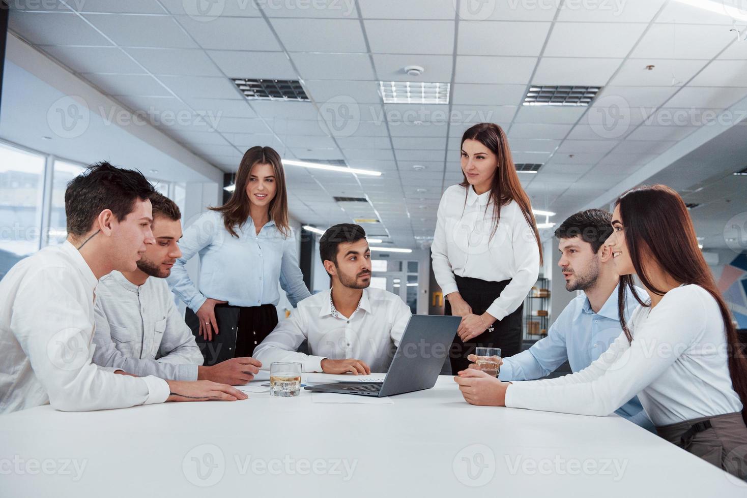 Vorstellung von Erfolg. Gruppe junger Freiberufler im Büro unterhalten sich und lächeln foto