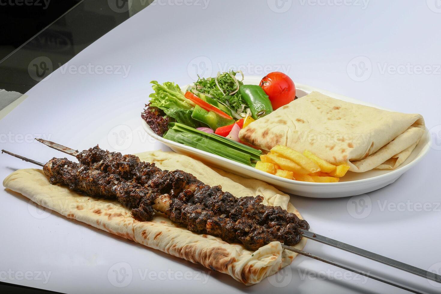 iranisch Tikka boti Kebab Teller mit Salat, Fritten, und Pita-Brot Brot serviert im Gericht Seite Aussicht von arabisch Essen foto