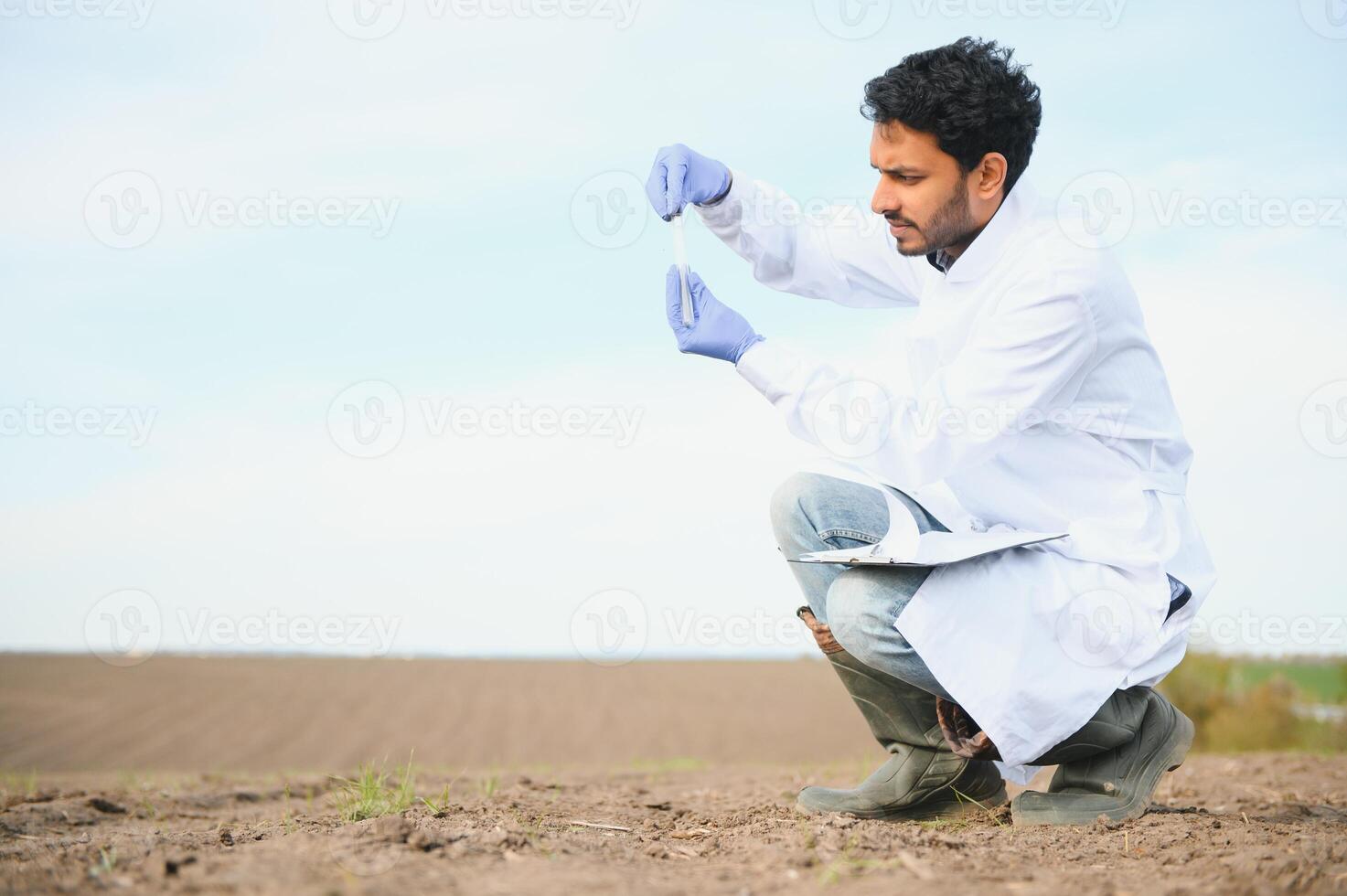 Boden testen. indisch Agronomie Spezialist nehmen Boden Stichprobe zum Fruchtbarkeit Analyse. Hände im Handschuhe schließen hoch. Umwelt Schutz, organisch Boden Zertifizierung, Feld arbeiten, Forschung foto