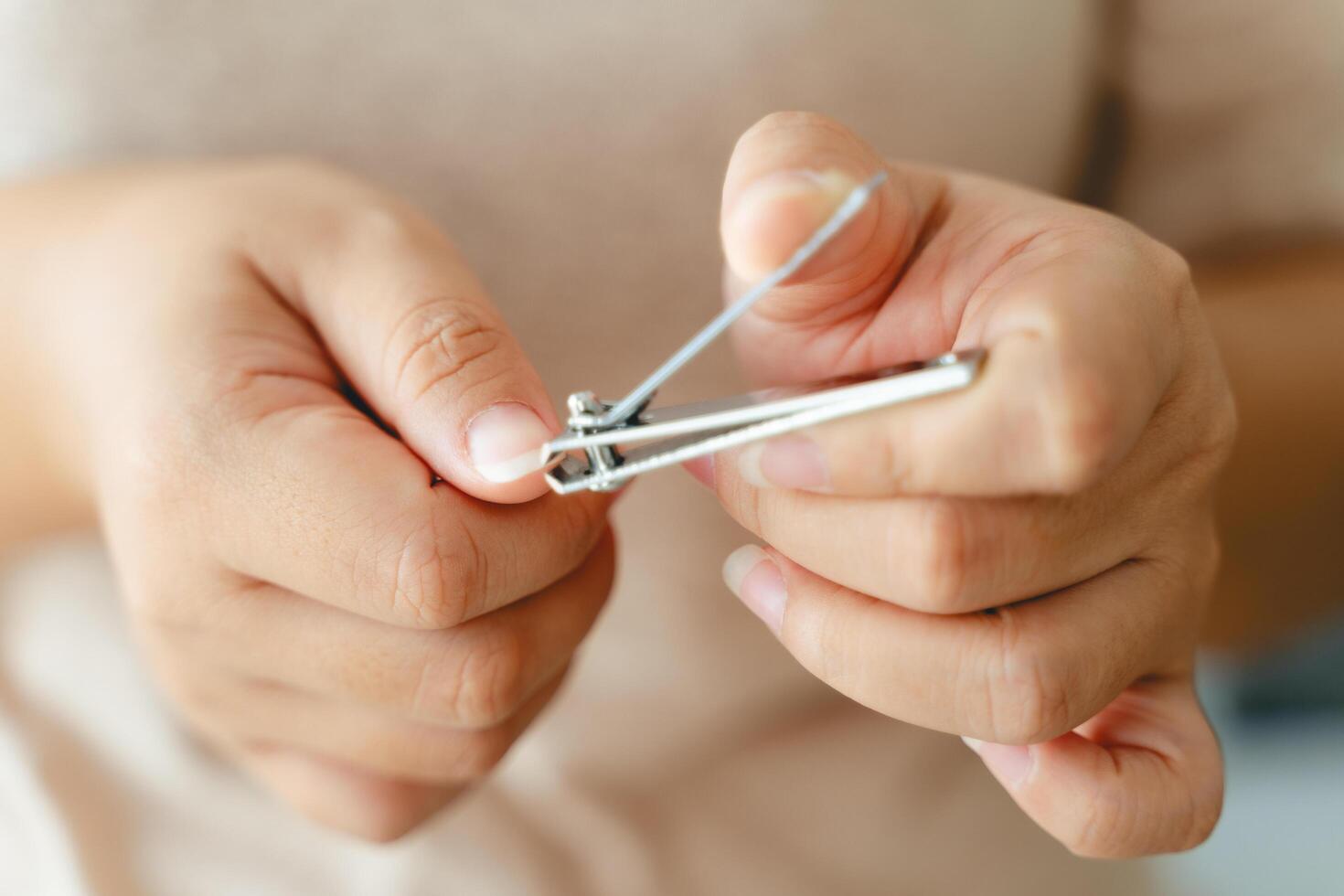 ein Frau ist halten ein Paar von Nagel Haarschneidemaschinen foto