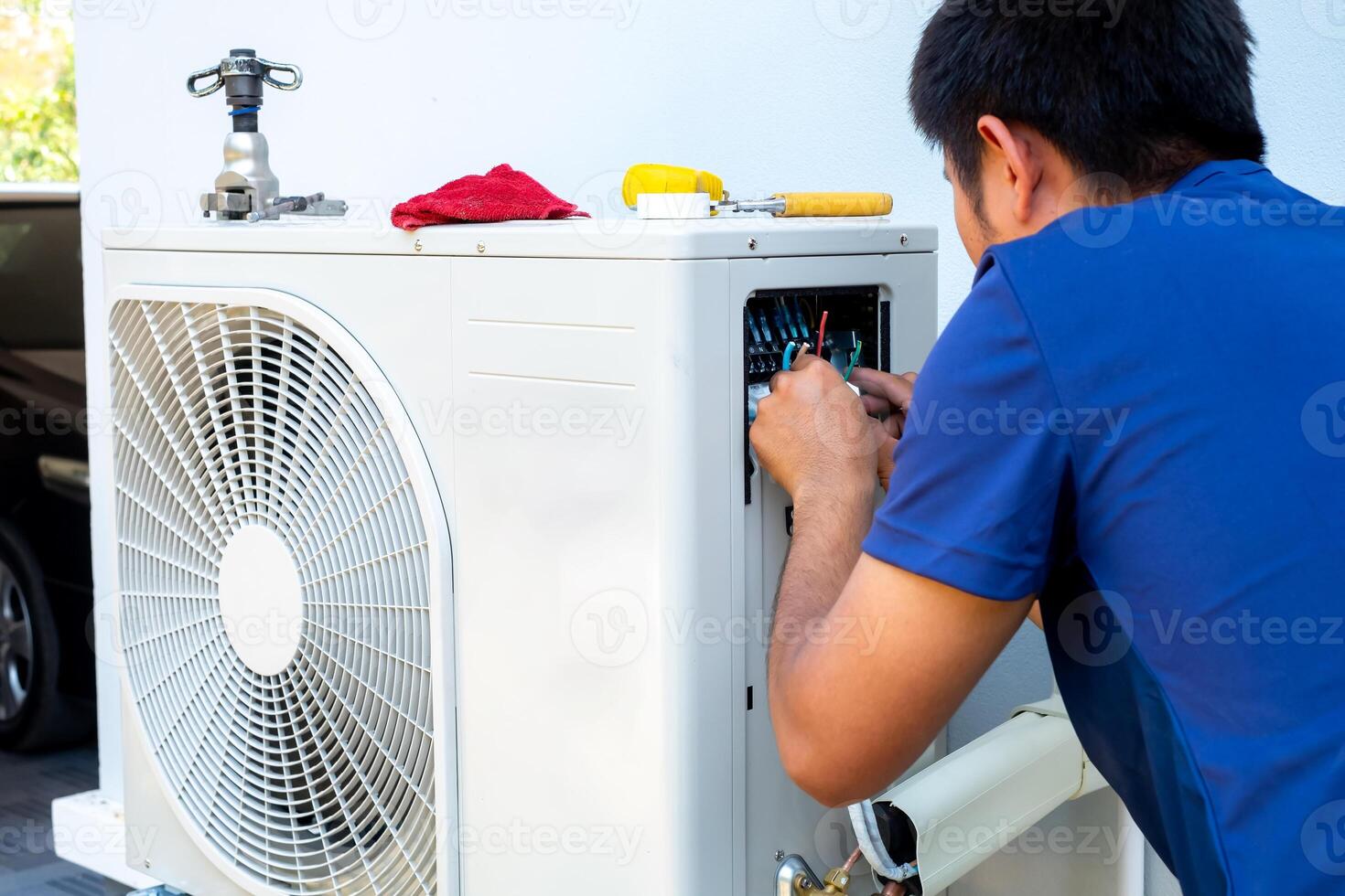 männlich Techniker Installation draussen Einheit von Luft Conditioner zu cool das Haushalt im das Sommer. Luft Kompressor, elektronisch, heiß Sommer, hoch Temperatur, tropisch Länder foto