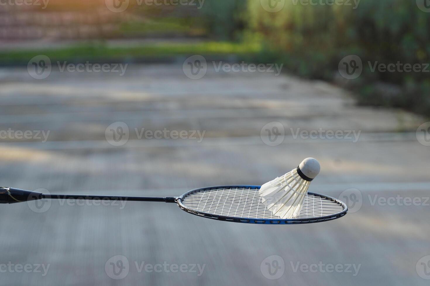 Weiß Sahne Badminton Federbälle auf Badminton Schläger, verschwommen Bäume Hintergrund, Konzept zum draussen Badminton spielen im kostenlos mal, Sanft und selektiv Fokus. foto