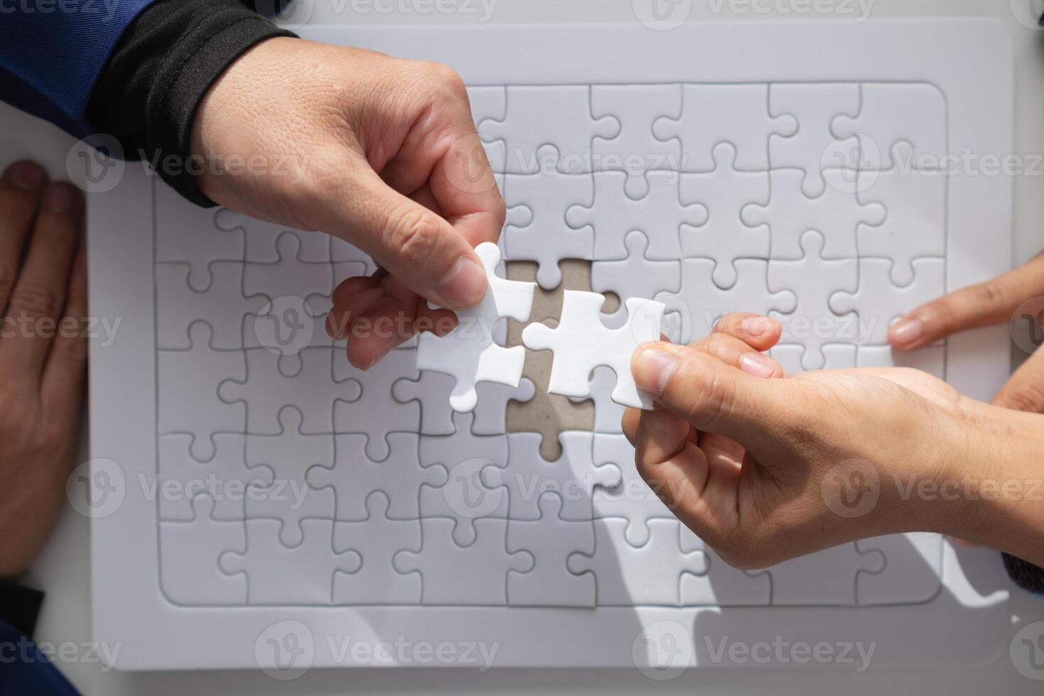 im Hände von Geschäftsleute und Investoren Sie halt Puzzle Stücke zu stellen zusammen im richtig Weg zu machen das Puzzle Stücke symbolisieren ihr Beteiligung im Geschäft Unternehmungen. wagen Hauptstadt Symbol Konzept foto