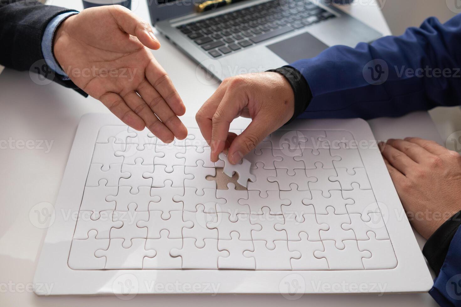 im Hände von Geschäftsleute und Investoren Sie halt Puzzle Stücke zu stellen zusammen im richtig Weg zu machen das Puzzle Stücke symbolisieren ihr Beteiligung im Geschäft Unternehmungen. wagen Hauptstadt Symbol Konzept foto