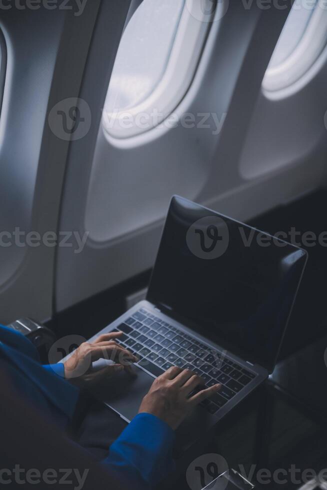 mit Handy, Mobiltelefon und Laptop, nachdenklich asiatisch Menschen weiblich Person am Bord, Flugzeug Fenster, perfekt Erfassung das Erwartung und Aufregung von Urlaub Reise. Chinesisch, japanisch Personen. foto