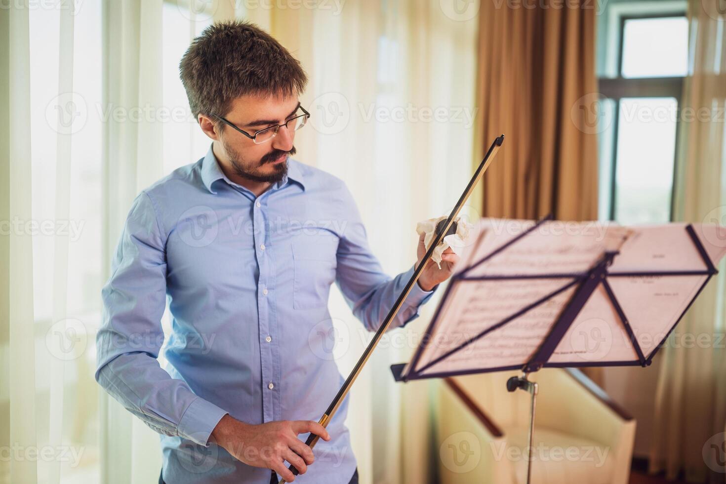 Mann spielen Violine beim heim. er Kolophonium ein Violine Bogen. foto