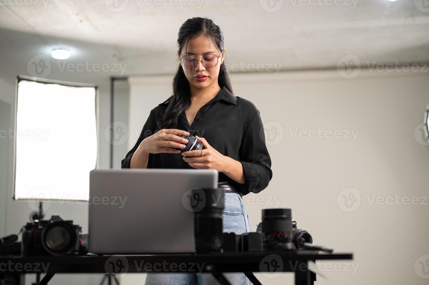 ein weiblich Fotograf ist vorbereiten ihr Kameras Linse zum ein Foto-Shooting, Arbeiten im ein Studio. foto