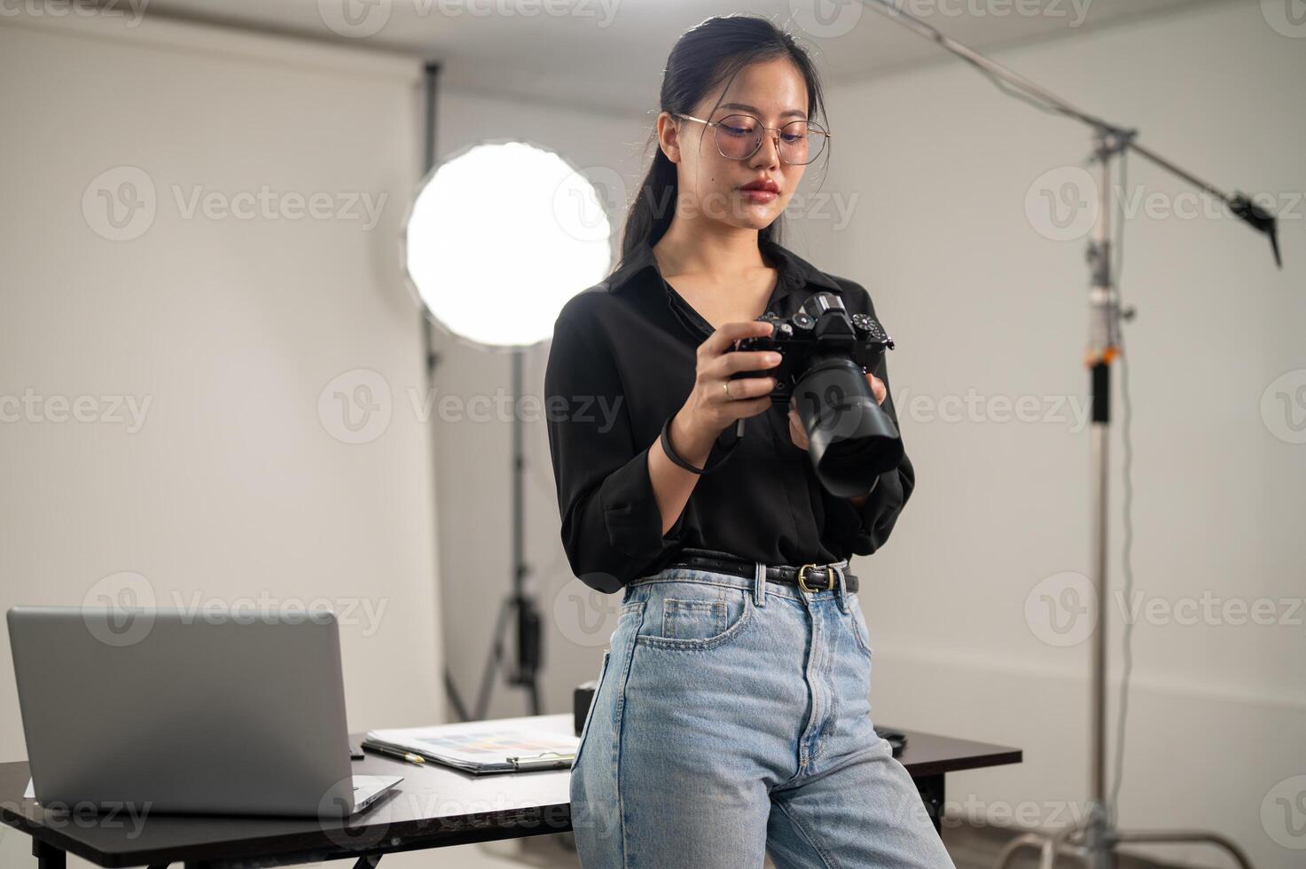 Fachmann asiatisch weiblich Fotograf ist Fokussierung auf einstellen ihr dslr Kamera, Arbeiten im ein Studio foto