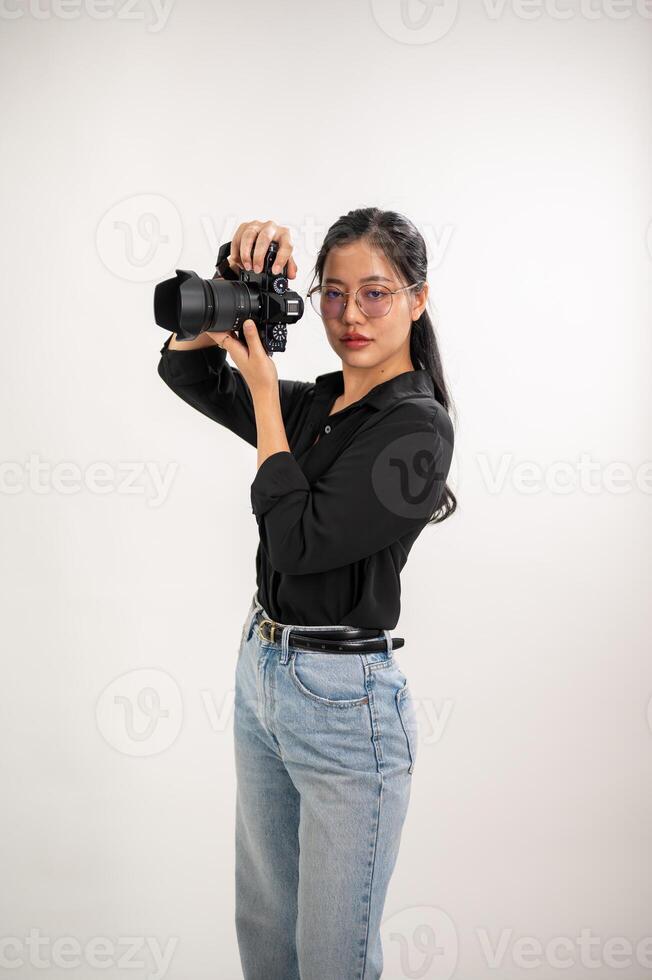 ein Fachmann, zuversichtlich asiatisch weiblich Fotograf ist nehmen Bilder im ein Fotoshooting Studio. foto