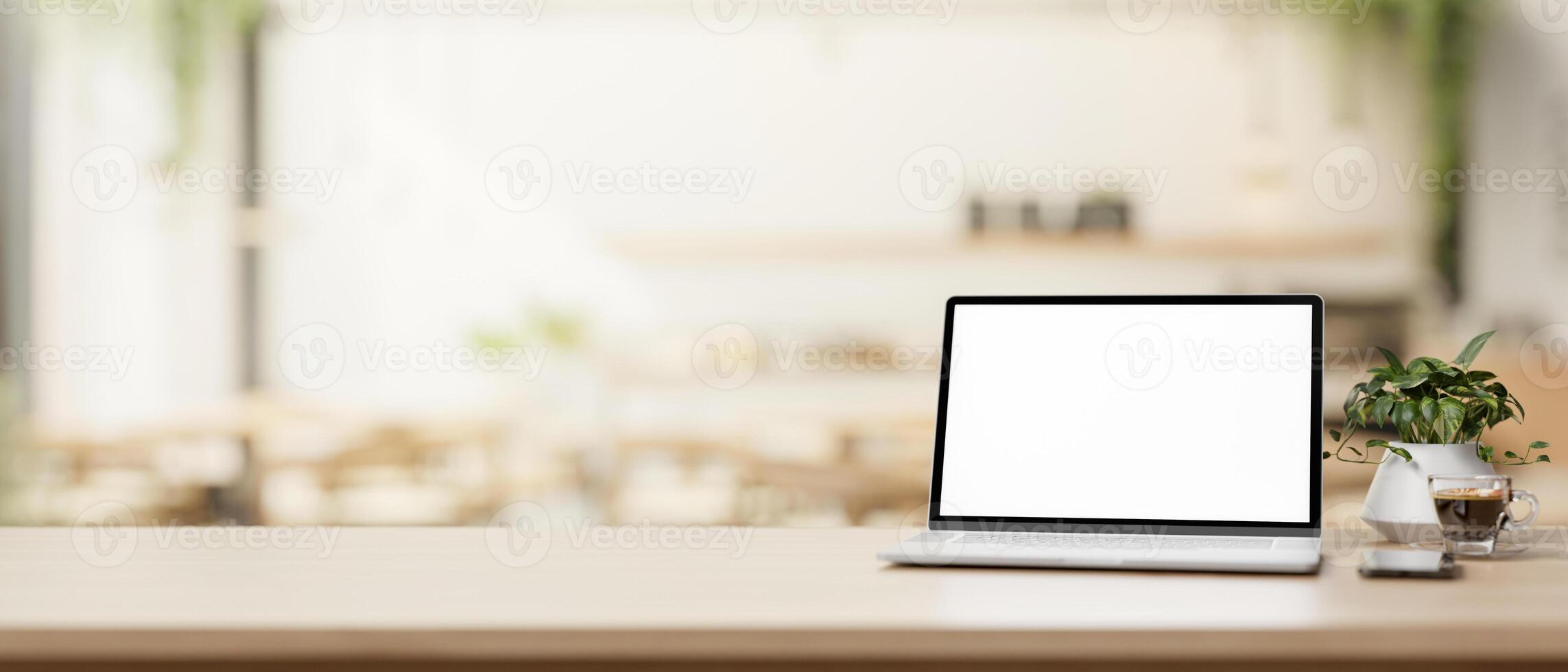 ein Laptop Computer und ein Präsentation Raum auf ein hölzern Tabelle im ein gemütlich, zeitgenössisch Kaffee Geschäft. foto