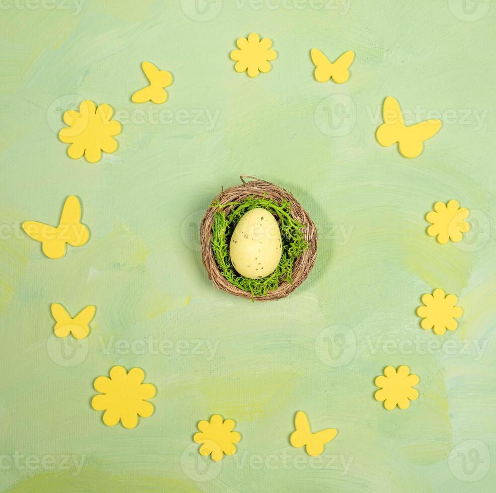 Ostern Ei im Nest Innerhalb von runden Rahmen von Gelb Blumen und Schmetterlinge auf Grün Gelb. oben Aussicht foto