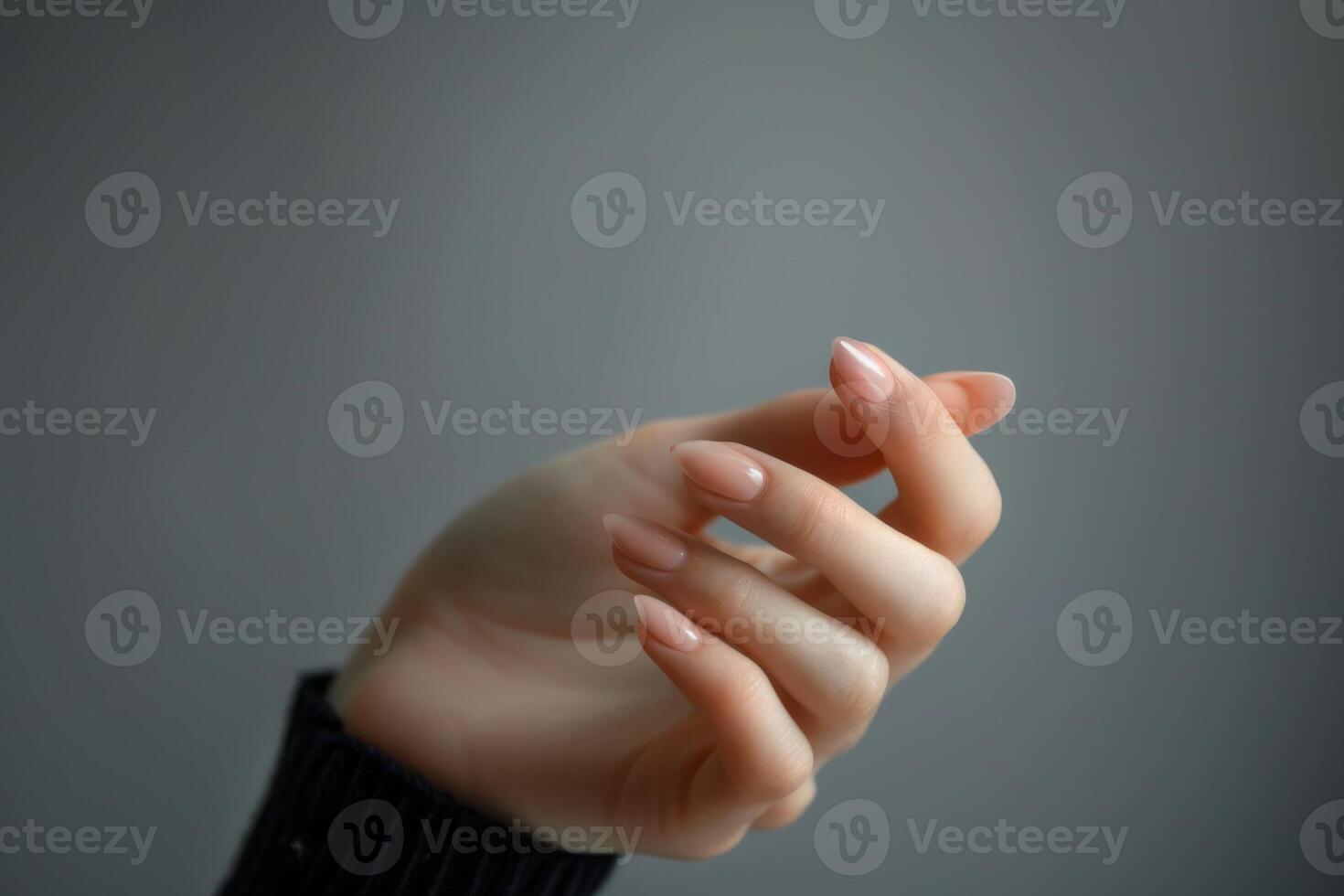 weiblich Hand mit Maniküre im nackt Stil. auf ein grau Hintergrund foto