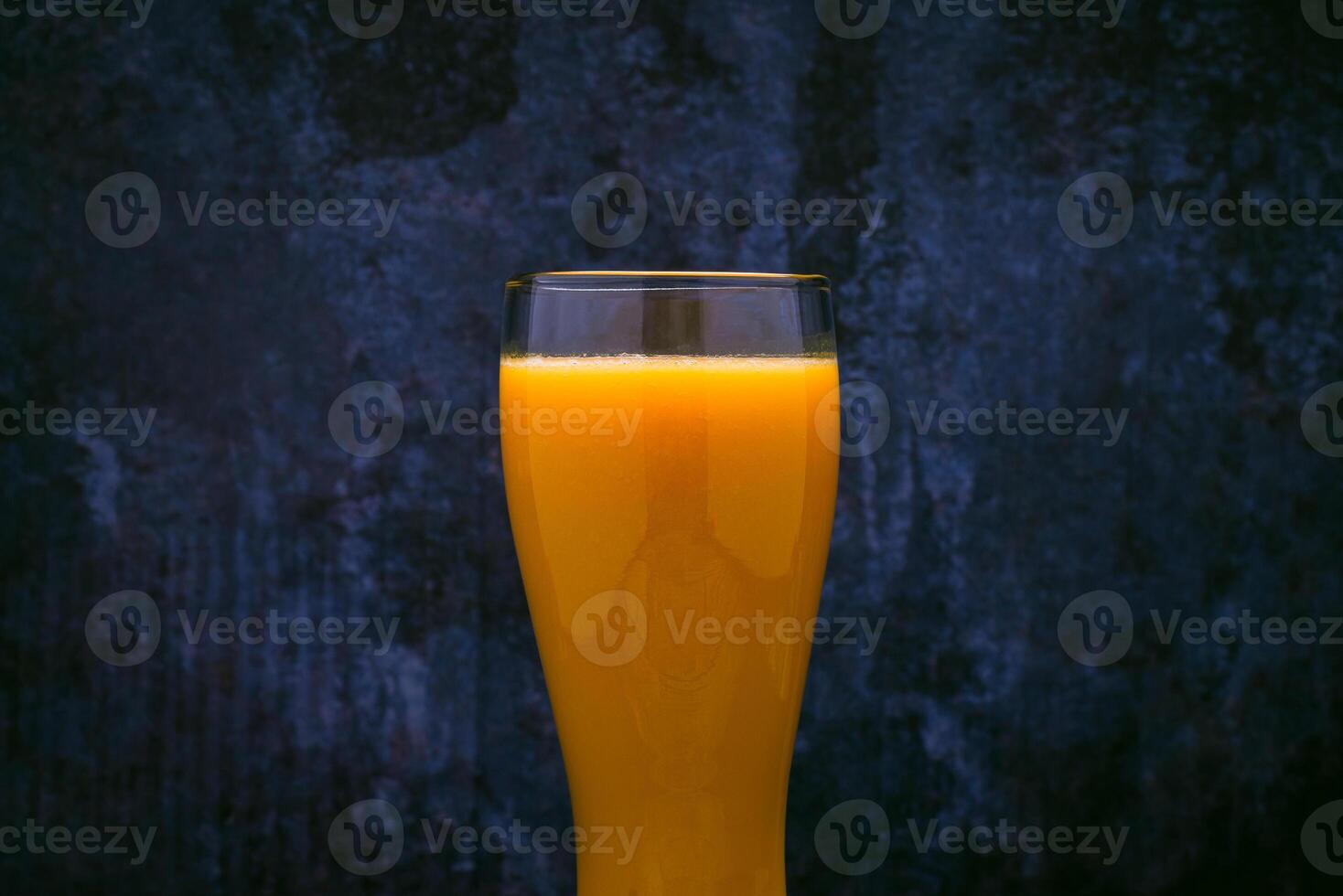 Glas mit Mango Saft. Blau Hintergrund. foto