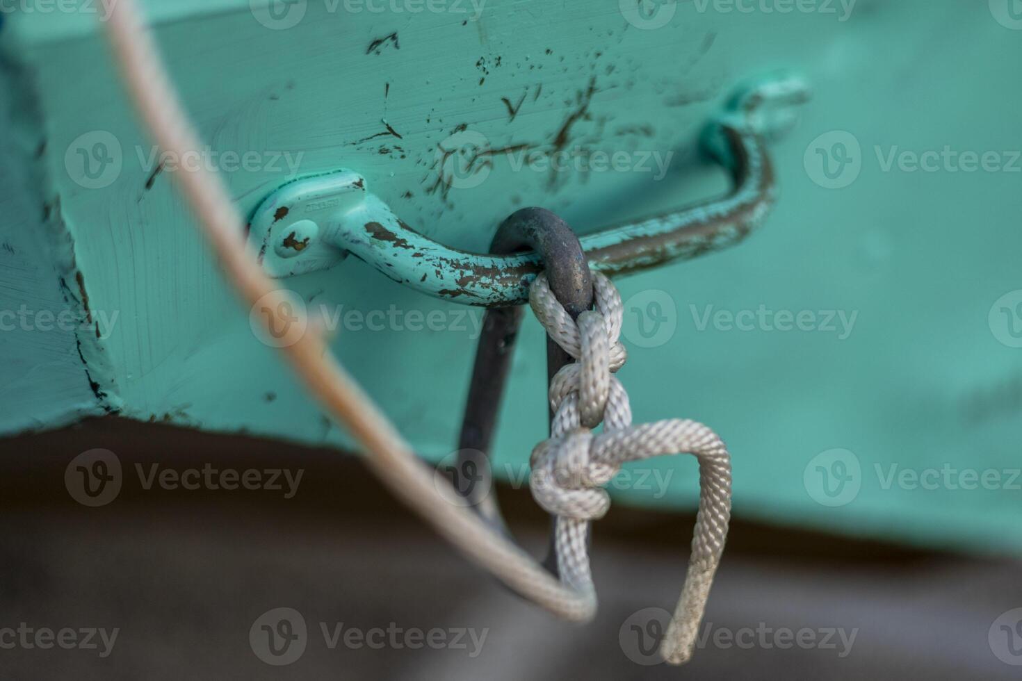 Seil befestigt zu ein Metall Griff Das ist aufgeschmissen in ein Ruderboot foto