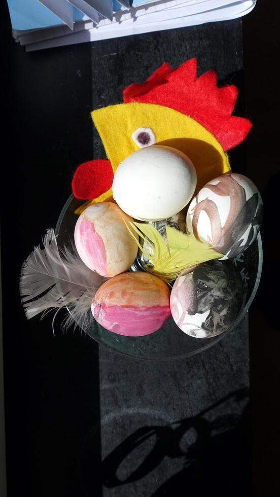 Eier gemalt mit ein Stoff Henne im das Hintergrund zu Wunsch jedermann glücklich Ostern foto