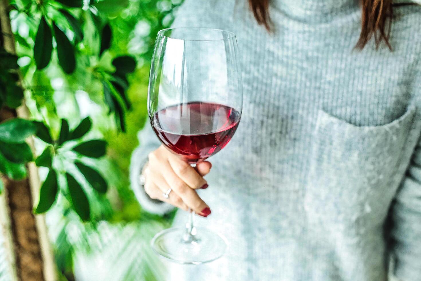 Frau halten ein Glas von rot Wein beim ein Abendessen Party foto