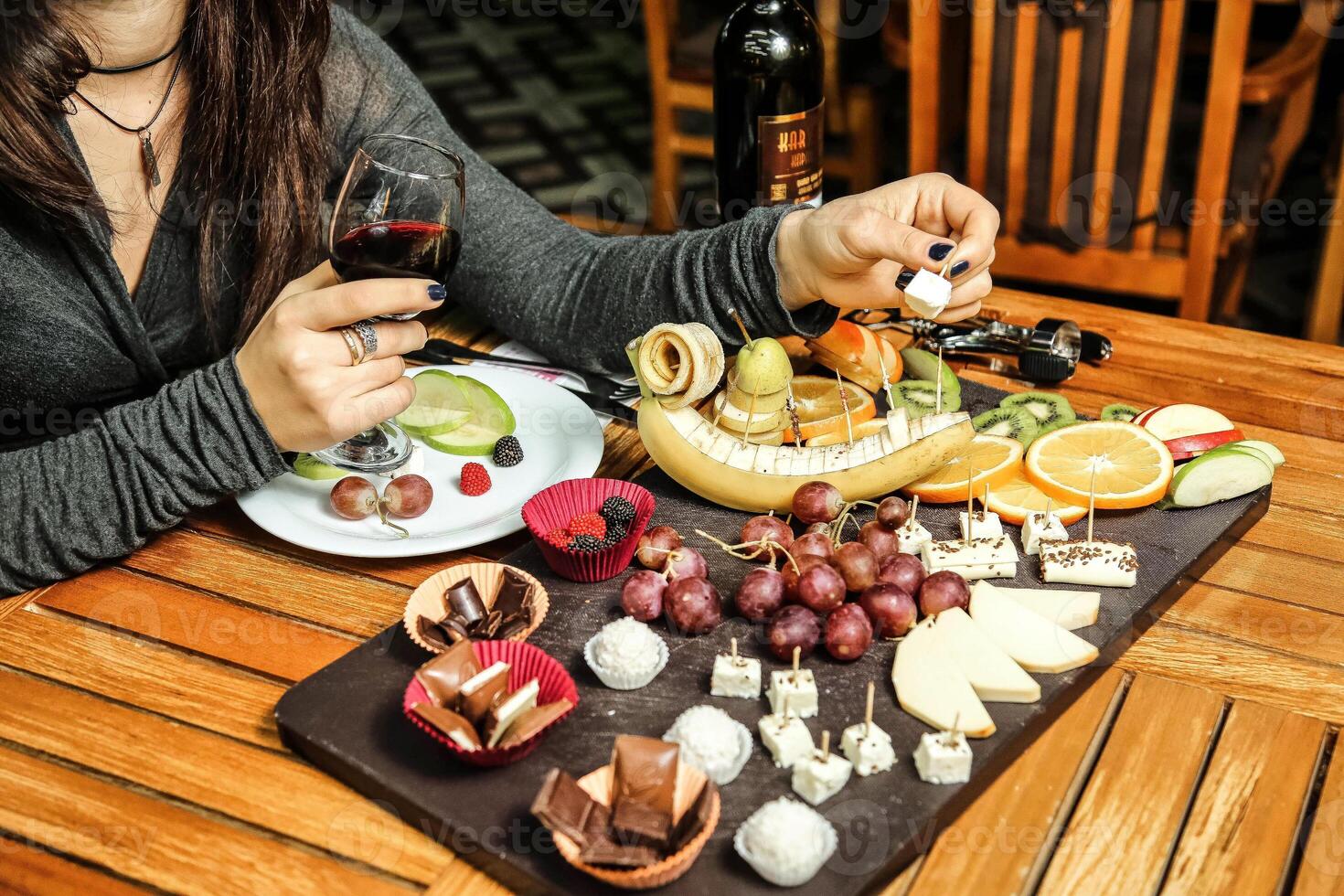 Frau Sitzung beim Tabelle mit Teller von Essen und Glas von Wein foto