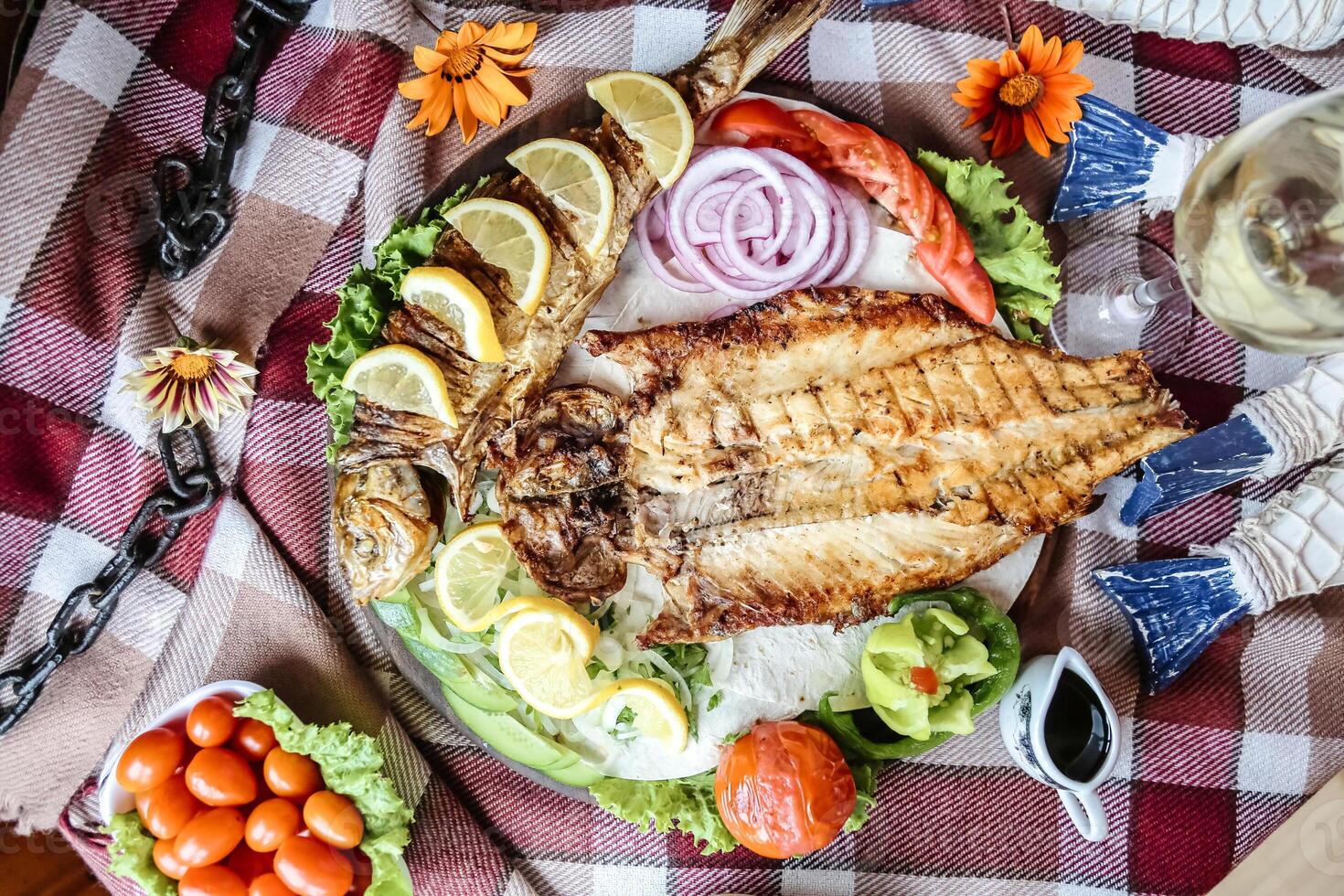 Teller von gegrillt Fisch und Gemüse auf ein Picknick Decke foto