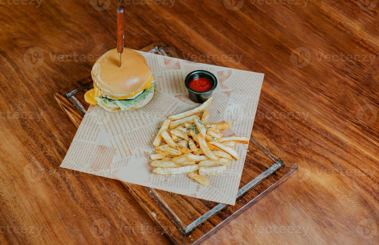 oben Aussicht von Cheeseburger mit Französisch Fritten serviert auf hölzern Tisch. köstlich Hamburger mit Französisch Fritten auf ein hölzern Tabelle foto