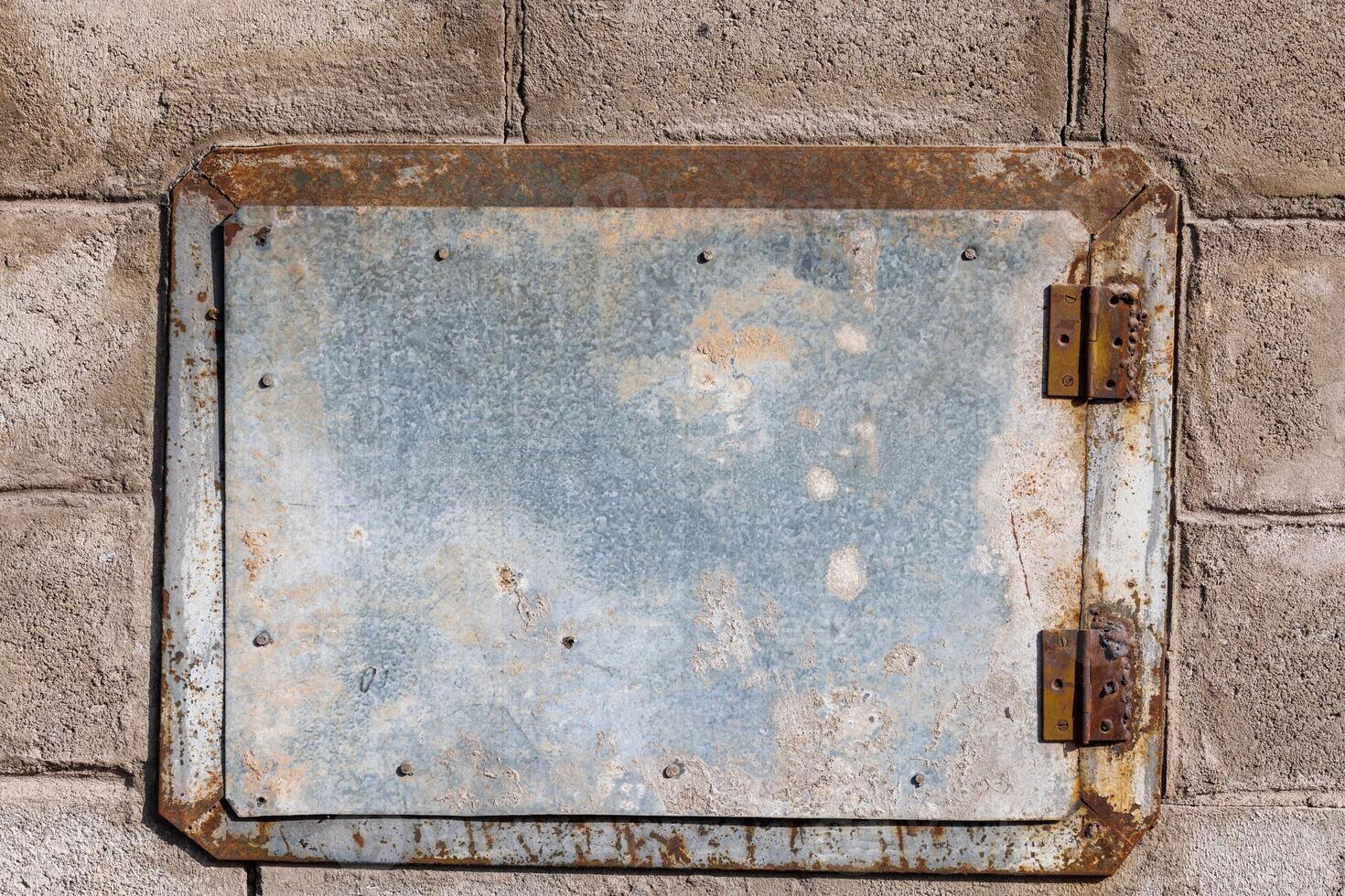 ein klein rechteckig Zink beschichtet Metall Luke montiert auf ein Backstein Mauer foto