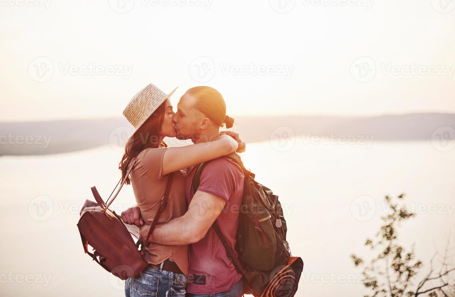 starke Beziehung. junges Paar hat beschlossen, seinen Urlaub aktiv am Rande des wunderschönen Felsens mit See im Hintergrund zu verbringen foto
