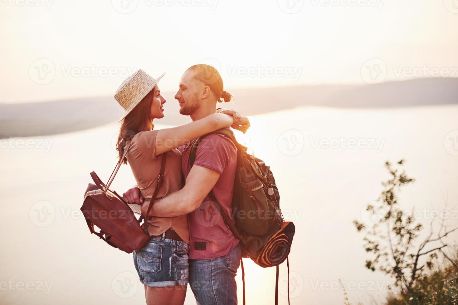 liebevolle Augen. junges Paar hat beschlossen, seinen Urlaub aktiv am Rande des wunderschönen Felsens mit See im Hintergrund zu verbringen foto