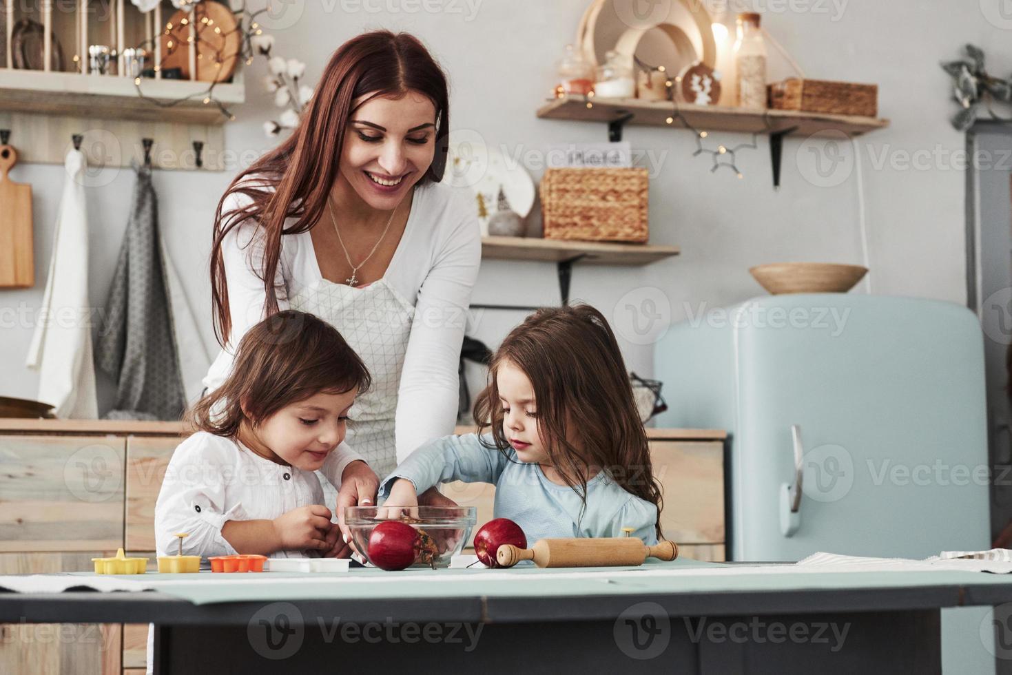 Dieses Mädchen hat das Essen speziell für sie zubereitet. junge schöne frau gibt die kekse, während sie mit spielzeug am tisch sitzen foto