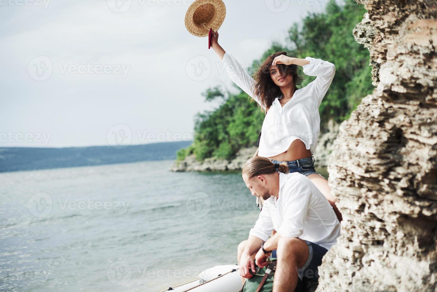 Freiheit in der Luft. Touristen, die mit der Reise zufrieden sind, die sie vor dem Hintergrund von Bäumen in der Nähe des Bootes machen? foto