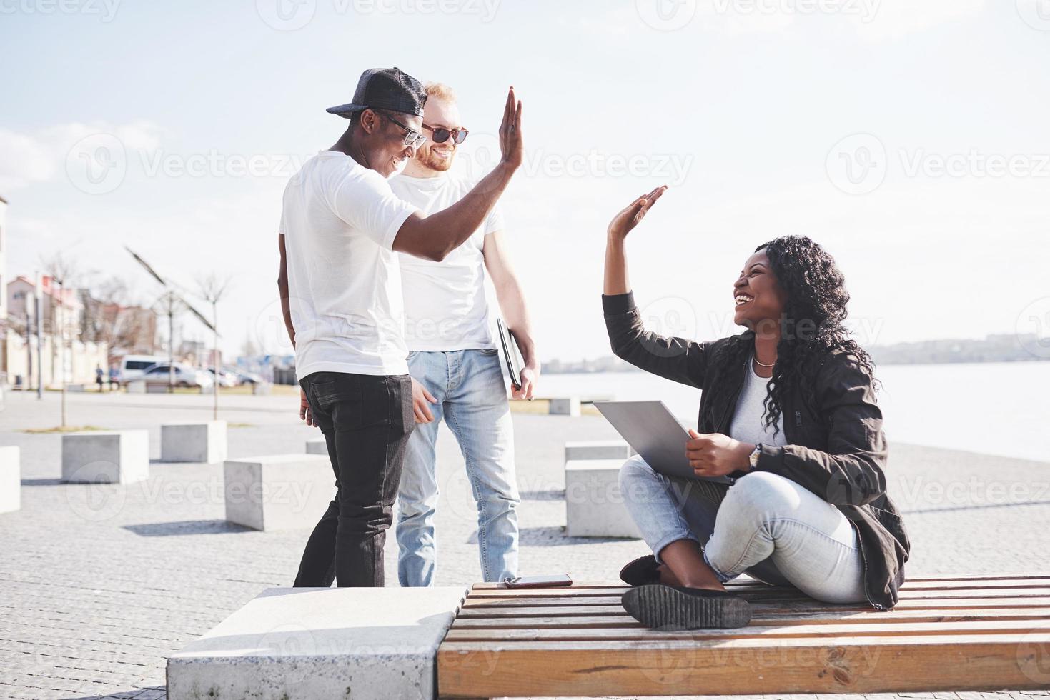 schöne multiethnische Freunde mit einem Laptop auf der Straße. Jugend-Lifestyle-Konzept foto