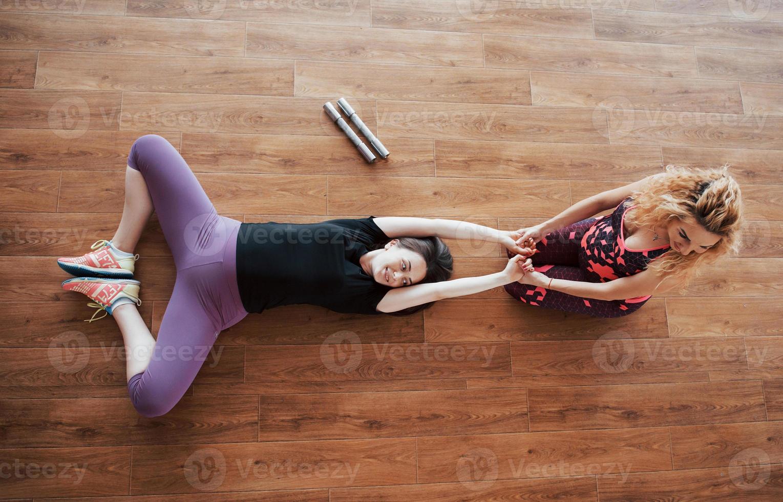 Schwangere Frau beim Yoga mit Personal Trainer. foto