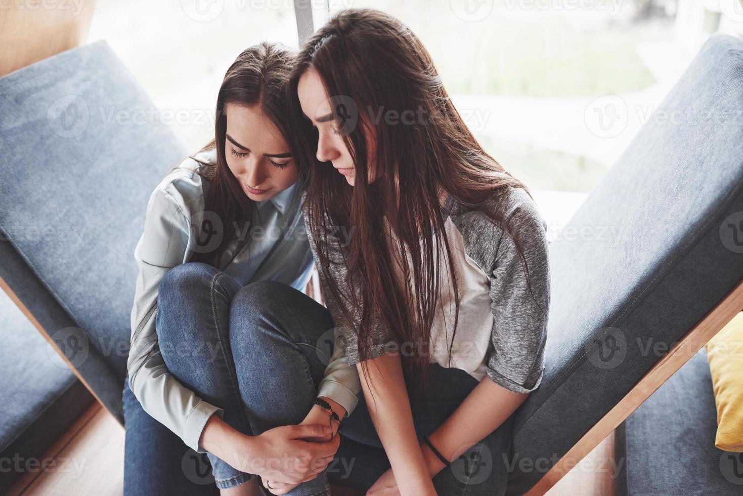 schönes junges mädchen verbringt ihre zeit im erholungsgebiet. Sie sitzt und hat Spaß im Sofasessel in Form eines Sechsecks mit Kissen in der Nähe des Fensters foto