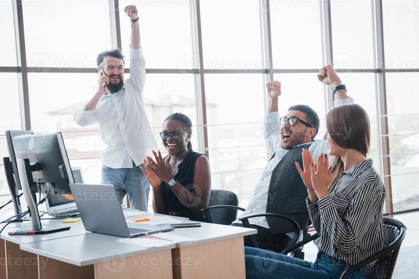 Junge Mitarbeiter, die im Büro am Tisch sitzen und einen Laptop verwenden, ein Teamwork-Brainstorming-Meeting-Konzept. foto