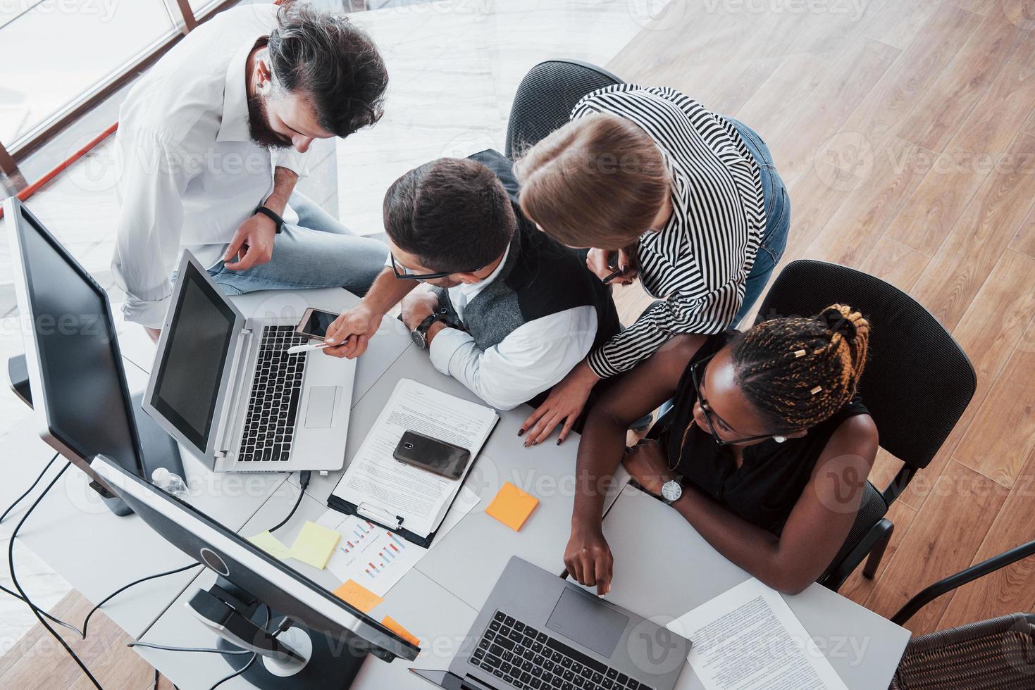 eine Gruppe multinationaler beschäftigter Leute, die im Büro arbeiten. foto