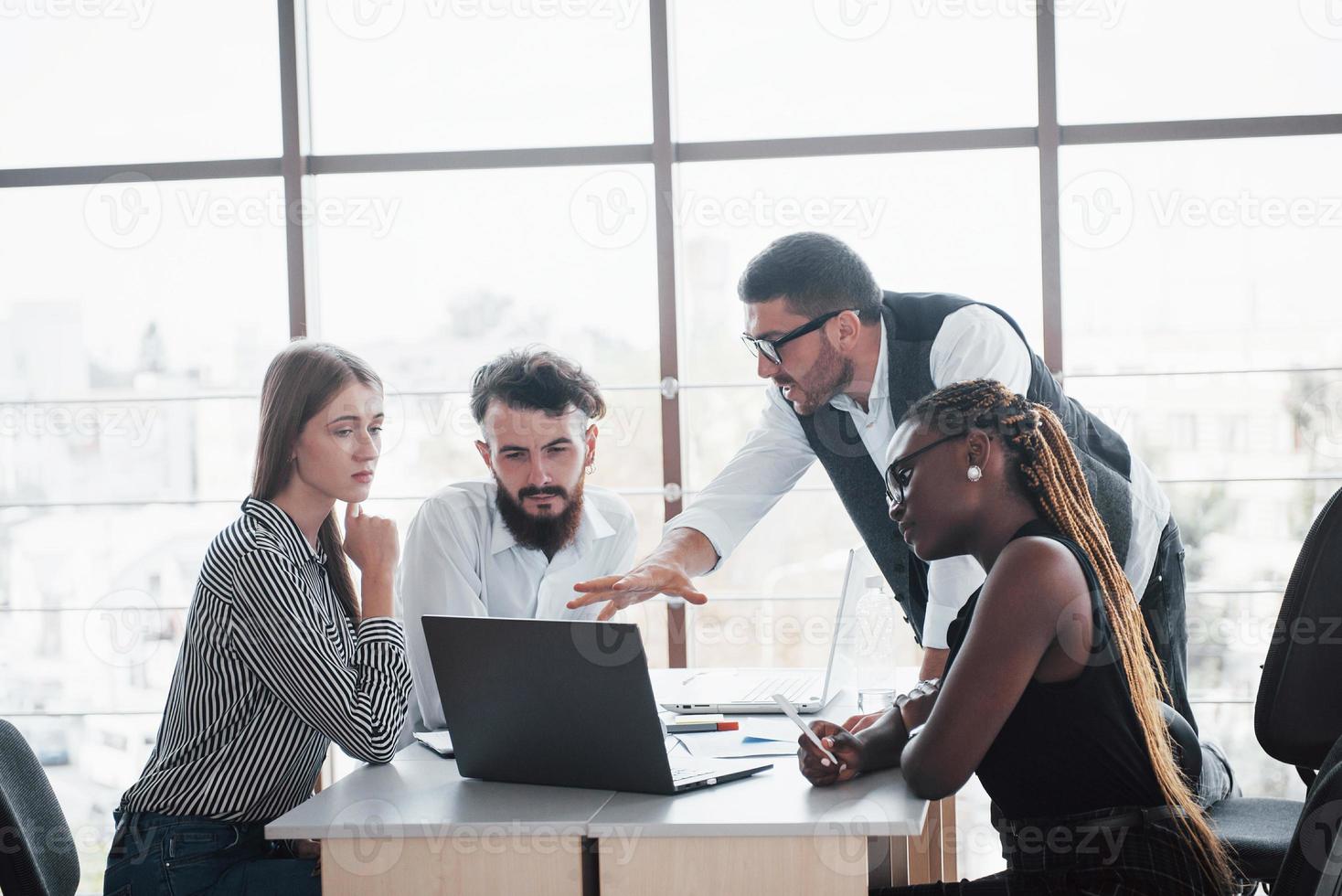 eine Gruppe multinationaler beschäftigter Leute, die im Büro arbeiten foto