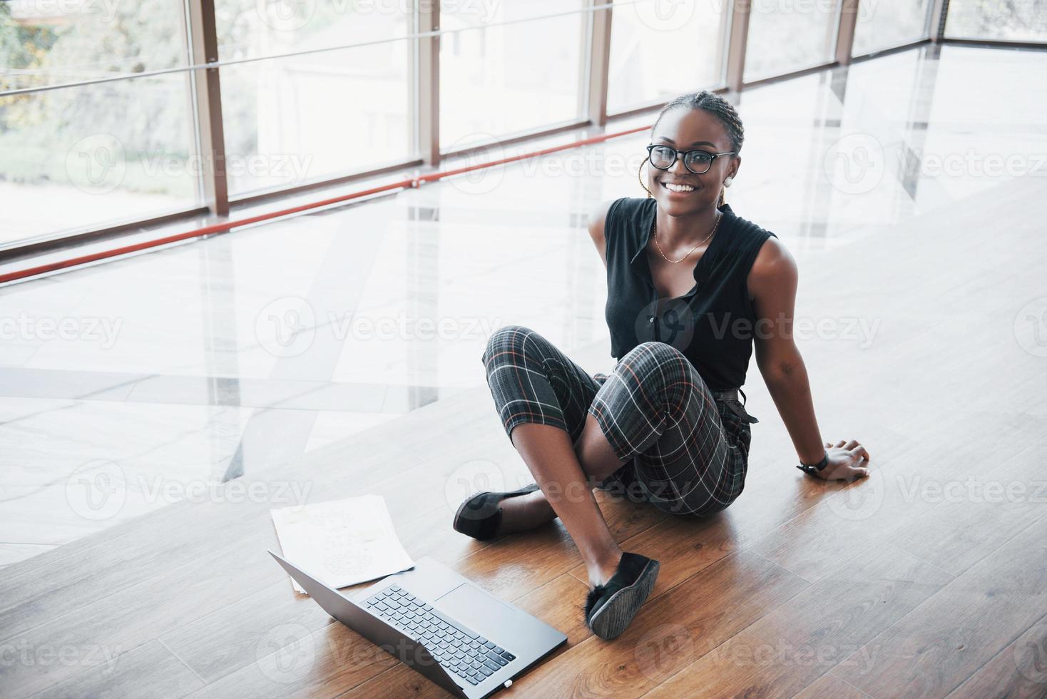 Eine junge Afroamerikanerin freut sich über einen Laptop. foto